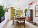 Charming dining room with modern light fixture, wood table and chairs, and bright window at 4492 Del Sol Blvd, Sarasota, FL 34243