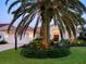 Inviting home with lush landscaping, a well-lit entrance, mature palm trees, and a two-car garage, enhancing the curb appeal at 4492 Del Sol Blvd, Sarasota, FL 34243