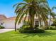 Charming single-story home with a well-manicured lawn, mature palm trees, and a white garage door, offering classic curb appeal at 4492 Del Sol Blvd, Sarasota, FL 34243