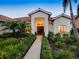 Inviting front entrance featuring double doors, lush landscaping, and a red tile roof, providing curb appeal at 4492 Del Sol Blvd, Sarasota, FL 34243