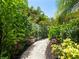 Enchanting garden path with a white fence, vibrant flowers, and lush foliage, perfect for a peaceful stroll at 4492 Del Sol Blvd, Sarasota, FL 34243