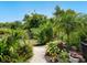 Scenic garden path with a white fence, lush greenery, and vibrant flowers, creating a tranquil oasis at 4492 Del Sol Blvd, Sarasota, FL 34243