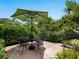 Charming outdoor dining area with a round table, set amidst a beautifully landscaped garden at 4492 Del Sol Blvd, Sarasota, FL 34243