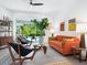 Bright living room with an orange sofa, modern furniture, and sliding doors to the pool at 4492 Del Sol Blvd, Sarasota, FL 34243