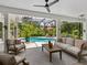 Inviting outdoor patio with comfortable seating, screened pool area, and lush landscaping for serene relaxation and gatherings at 4492 Del Sol Blvd, Sarasota, FL 34243
