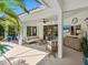 Bright and spacious patio boasts a view of the pool and lush landscaping, perfect for relaxing and entertaining guests at 4492 Del Sol Blvd, Sarasota, FL 34243