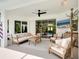 Comfortable covered patio featuring ceiling fan, neutral furniture, and a TV for outdoor entertainment at 4492 Del Sol Blvd, Sarasota, FL 34243