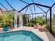 Relaxing pool area featuring a screened enclosure, comfortable seating, and lush landscaping for ultimate privacy at 4492 Del Sol Blvd, Sarasota, FL 34243