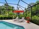 Relaxing pool area with lounge chairs and a vibrant umbrella, offering a tranquil outdoor retreat at 4492 Del Sol Blvd, Sarasota, FL 34243