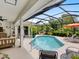 Inviting screened-in pool with covered patio featuring comfortable seating and a lush, tropical backdrop at 4492 Del Sol Blvd, Sarasota, FL 34243