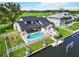 Aerial view of the home showcasing the pool, boat lift, fenced yard, and waterfront location at 4506 17Th W St, Palmetto, FL 34221