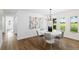Dining room with a modern white table, seating for six, white walls, and natural light from the windows at 4506 17Th W St, Palmetto, FL 34221