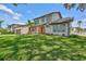 A front view of a charming home with lush green grass, complemented by surrounding trees and a blue sky at 4506 17Th W St, Palmetto, FL 34221