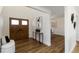 View of the foyer with wood flooring, a double-door entrance, bench, and a decorative table with plants and a painting at 4506 17Th W St, Palmetto, FL 34221