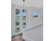 Stairway with modern chandelier and high windows showing a lush landscape at 4506 17Th W St, Palmetto, FL 34221
