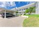 Inviting two-story condo building featuring a carport, manicured lawn, and tropical landscaping at 4736 Independence Dr # 4736, Bradenton, FL 34210