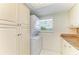 Bright laundry area with stacked washer and dryer, storage cabinets, and tile flooring at 4736 Independence Dr # 4736, Bradenton, FL 34210