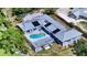 Aerial view of a home with a pool, deck, solar panels and a well-manicured lawn at 4771 Riverwood Cir, Sarasota, FL 34231