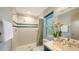 Well-lit bathroom featuring a tiled shower, modern sink and an orchid on the counter at 4771 Riverwood Cir, Sarasota, FL 34231