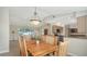 Open-concept dining area with a chandelier, view into living room, and modern kitchen in background at 4771 Riverwood Cir, Sarasota, FL 34231