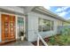 Close-up of the front entrance with a decorative door, tile flooring, and lush landscaping at 4771 Riverwood Cir, Sarasota, FL 34231