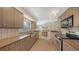 Well-lit kitchen with stainless steel appliances, tile flooring, wood cabinets and dining area at 4771 Riverwood Cir, Sarasota, FL 34231
