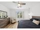 Bright main bedroom with modern lighting, ceiling fan, and dresser near the window at 4833 San Palermo Dr, Bradenton, FL 34208