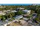 Beautiful aerial view showcasing the home, street, and nearby buildings with an ocean view in the background at 5026 Calle Minorga, Sarasota, FL 34242