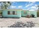 Home's backyard with white gravel, patio set, grill, and a view of the turquoise home exterior at 5026 Calle Minorga, Sarasota, FL 34242