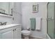 Cozy bathroom features a vanity sink, toilet, and shower with white tile and decorative shelving at 5026 Calle Minorga, Sarasota, FL 34242