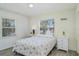 Bright bedroom featuring a comfortable bed, side tables, and two bright windows at 5026 Calle Minorga, Sarasota, FL 34242