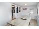 Bright dining room with a light colored table and doorway to the kitchen at 5026 Calle Minorga, Sarasota, FL 34242