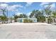 Charming single-story beach home featuring a metal roof and tropical landscaping and a large, sandy yard at 5026 Calle Minorga, Sarasota, FL 34242