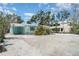 Charming single-story beach home featuring a metal roof and tropical landscaping and shell-covered yard at 5026 Calle Minorga, Sarasota, FL 34242