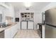 Well-organized laundry area with a washer, dryer, and shelving at 5026 Calle Minorga, Sarasota, FL 34242