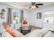 Inviting living room with a comfortable sofa, ceiling fan, and natural light from a large window at 5026 Calle Minorga, Sarasota, FL 34242