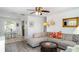 Inviting living room with a comfortable sectional sofa, ceiling fan, and view into the kitchen at 5026 Calle Minorga, Sarasota, FL 34242