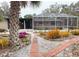 Backyard with screened patio and lush landscaping, brick pathways and water feature at 5353 Shadow Lawn Dr, Sarasota, FL 34242