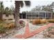 Beautiful backyard featuring lush gardens, mature trees, and an enclosed screened patio at 5353 Shadow Lawn Dr, Sarasota, FL 34242
