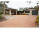 Inviting exterior showcasing a brick driveway, carport, and well-maintained landscaping at 5353 Shadow Lawn Dr, Sarasota, FL 34242