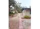 A home exterior featuring a brick pathway, side yard with greenery, and neutral siding at 5353 Shadow Lawn Dr, Sarasota, FL 34242