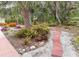 Brick pathways with tropical landscaping leads to backyard water feature and patio at 5353 Shadow Lawn Dr, Sarasota, FL 34242