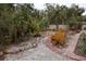 Lush landscaping with palm trees, bromeliads, and a brick path creates a tropical outdoor oasis at 5353 Shadow Lawn Dr, Sarasota, FL 34242