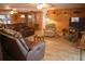 Cozy living room with wood-paneled walls, tile floors, ceiling fans, and comfortable seating arrangements at 5353 Shadow Lawn Dr, Sarasota, FL 34242