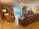 Inviting living room shows wood-paneled walls, tile floors, ceiling fans, and access to patio at 5353 Shadow Lawn Dr, Sarasota, FL 34242