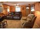 Comfortable living room with wood-paneled walls, tile floors, ceiling fans, and leather seating at 5353 Shadow Lawn Dr, Sarasota, FL 34242