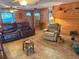 Relaxing living room with wood-paneled walls, tile floors, ceiling fans, and comfy seating at 5353 Shadow Lawn Dr, Sarasota, FL 34242
