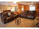 Comfortable living room boasts wood-paneled walls, tile floors, ceiling fans, and plush sofas at 5353 Shadow Lawn Dr, Sarasota, FL 34242