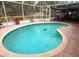 Inviting screened-in pool area with covered patio, brick pavers, and lush landscaping at 5353 Shadow Lawn Dr, Sarasota, FL 34242