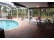 Covered screened porch with brick patio and pool, perfect for outdoor dining and relaxation at 5353 Shadow Lawn Dr, Sarasota, FL 34242